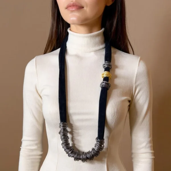 🖤 Sleek, sculptural, and full of possibility—the Knotty Long Necklace is designed for those who gravitate toward texture-rich styling and customizable elegance. Measuring 44 inches and weighing 16 ounces, this versatile piece offers a generous canvas for creative expression. Its elongated form can be worn in a single dramatic line or doubled for a fuller, collar-like silhouette. Wired beads run along the black cord in a flexible layout that responds to your mood: leave them spaced for fluid minimalism or gather them to create clustered statements. This interplay between open space and deliberate grouping lends the design a subtle, knotty sophistication—structured yet organic, playful yet poised. The necklace’s name hints at the artistry behind its creation. Each arrangement carries a knotty visual rhythm, drawing the eye to moments of tension and release, echoing the curves and coils found in nature or hand-sculpted form. It’s more than just accessory—it’s composition in motion. Ideal for the creative dresser, it transitions seamlessly from gallery nights to weekend escapes. The Knotty Long Necklace doesn’t follow rules—it rewrites them, embracing complexity, personality, and expressive layering. Style it loose. Style it close. Either way, it becomes part of your narrative.