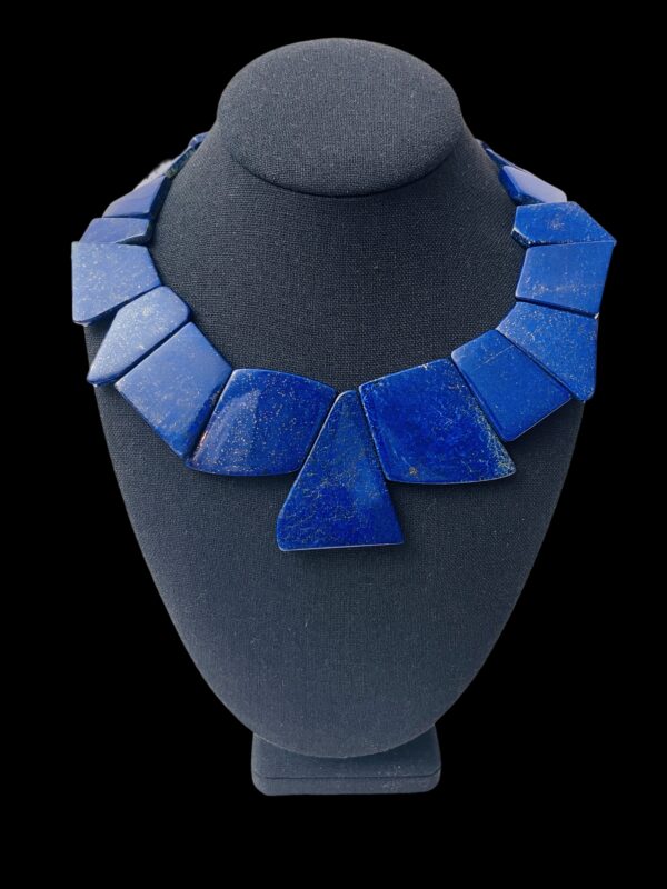 This is a large-cut, polished, irregular-shaped genuine natural stone Lapis Lazuli. The necklace measures 17 IN/7 OZ.  The center bead measures 2 IN.