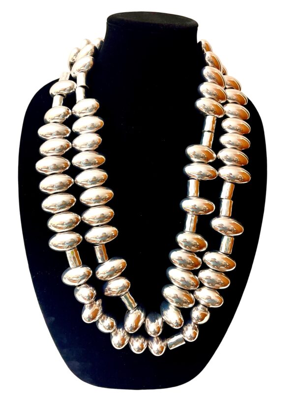 Sophisticated and elegant display of silver oval-shaped beads. You can wear the necklace with casual or formal attire in one, two, or even three strands. The necklace necklace measures 65 IN/20 OZ. The necklace will show extra cord to make the neck curve if you wear it in multiple layers.