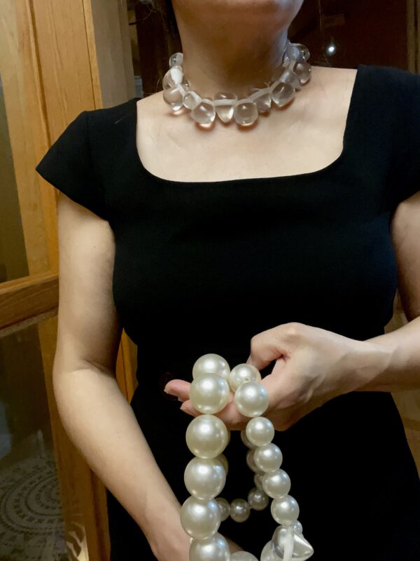 A set of 2 strands of medium-sized simulation pearls, with a separate choker necklace of one clear resin, tooth-shaped clear beads. You can wear the set or wear one or the other. The clear beads necklace contrasts the pearls' formality but also brings out the shine of the beads. The combination of styles is a unique statement for day or night. The necklace includes an extension to elongate both necklaces as a set or only one. This item sells as a set. The clear beads choker measures 16 IN/5 OZ. The double-strand necklace measures 17 IN/ 10 OZ Extension up to 5 IN A set 16 IN/15 OZ