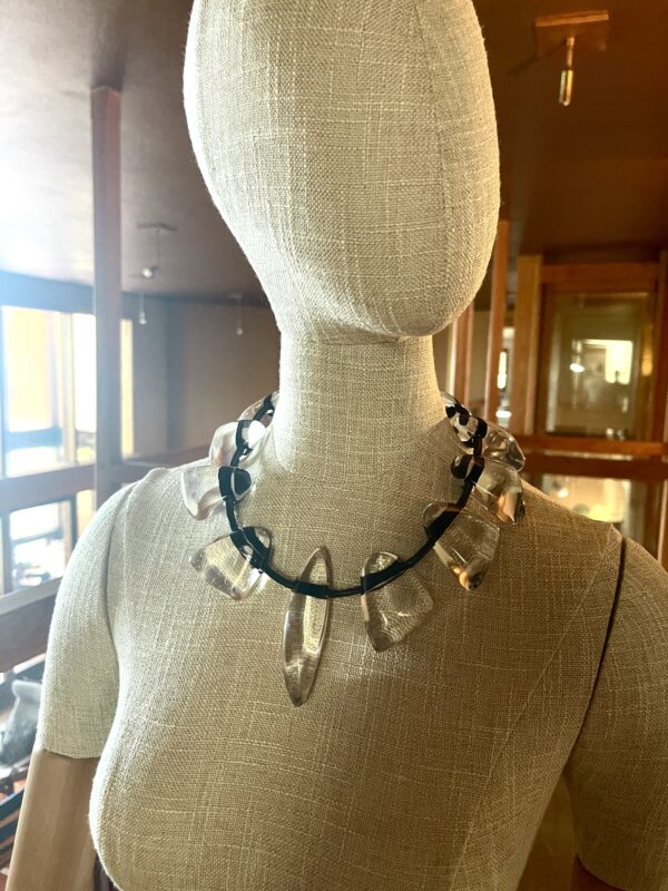 This necklace is fun, simple, and almost minimalist. The clear beads are easy to wear, and the standard black cord makes an informal contrast with the elegant clear beads. The necklace measures 20 IN/8 OZ.