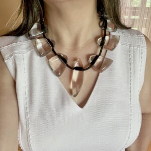 This necklace is fun, simple, and almost minimalist. The clear beads are easy to wear, and the standard black cord makes an informal contrast with the elegant clear beads. The necklace measures 20 IN/8 OZ.