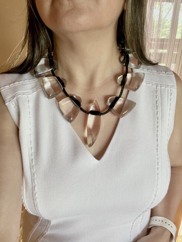 This necklace is fun, simple, and almost minimalist. The clear beads are easy to wear, and the standard black cord makes an informal contrast with the elegant clear beads. The necklace measures 20 IN/8 OZ.