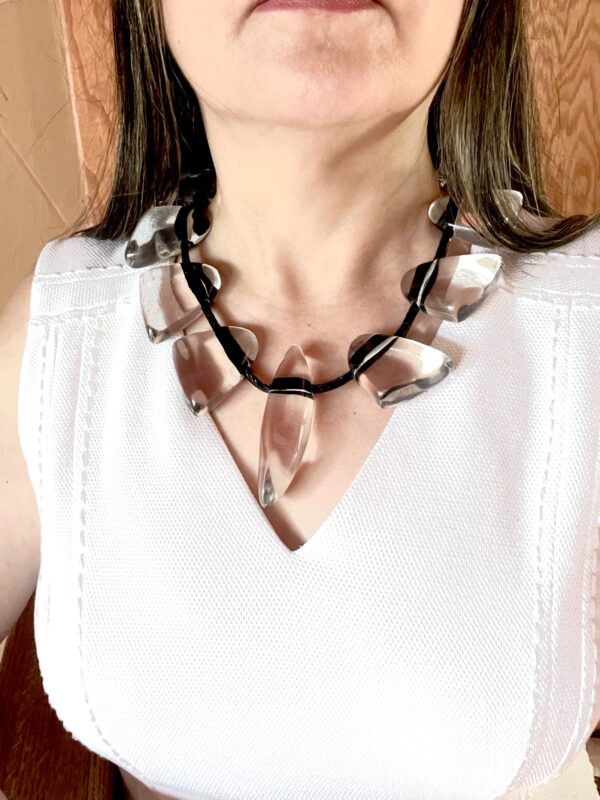 This necklace is fun, simple, and almost minimalist. The clear beads are easy to wear, and the standard black cord makes an informal contrast with the elegant clear beads. The necklace measures 20 IN/8 OZ.