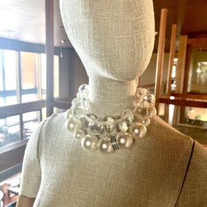A set of 2 necklaces. One medium-sized simulation pearls, one choker necklace of resin, tooth-shaped clear beads. You can wear the set or wear one or the other. The clear beads necklace contrasts the pearls' formality but also brings out the shine of the beads. The combination of styles is a unique statement for day or night. The necklace includes an extension to elongate both necklaces as a set or only one. This item sells as a set. The clear beads choker measures 15 IN/5 OZ. The pear beads necklace measures 19 IN/6 OZ. Extension up to 5 IN. A set 19 IN/11 OZ