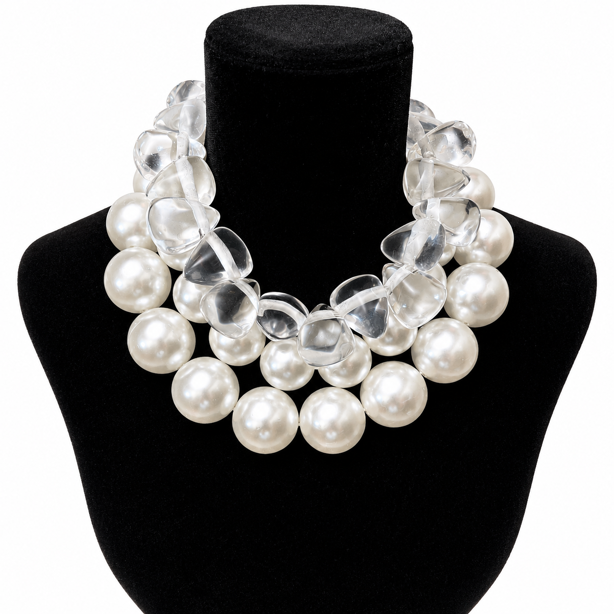 Two necklaces displayed side by side: one featuring double strands of glossy cream-colored simulated pearls arranged in a graduated pattern, and the other composed of translucent, frosted resin beads shaped like cones. Both pieces have silver clasps and exude a modern yet classic aesthetic.