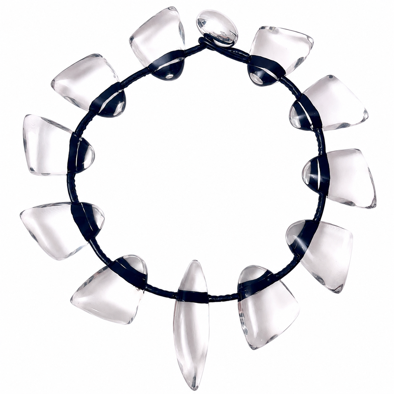 Circular necklace composed of clear, sculptural resin beads shaped like elongated cones and ovals. Each bead is strung on a sleek black cord, evenly spaced to create a modern, geometric silhouette. The transparent beads catch light beautifully, emphasizing their smooth, polished surfaces.