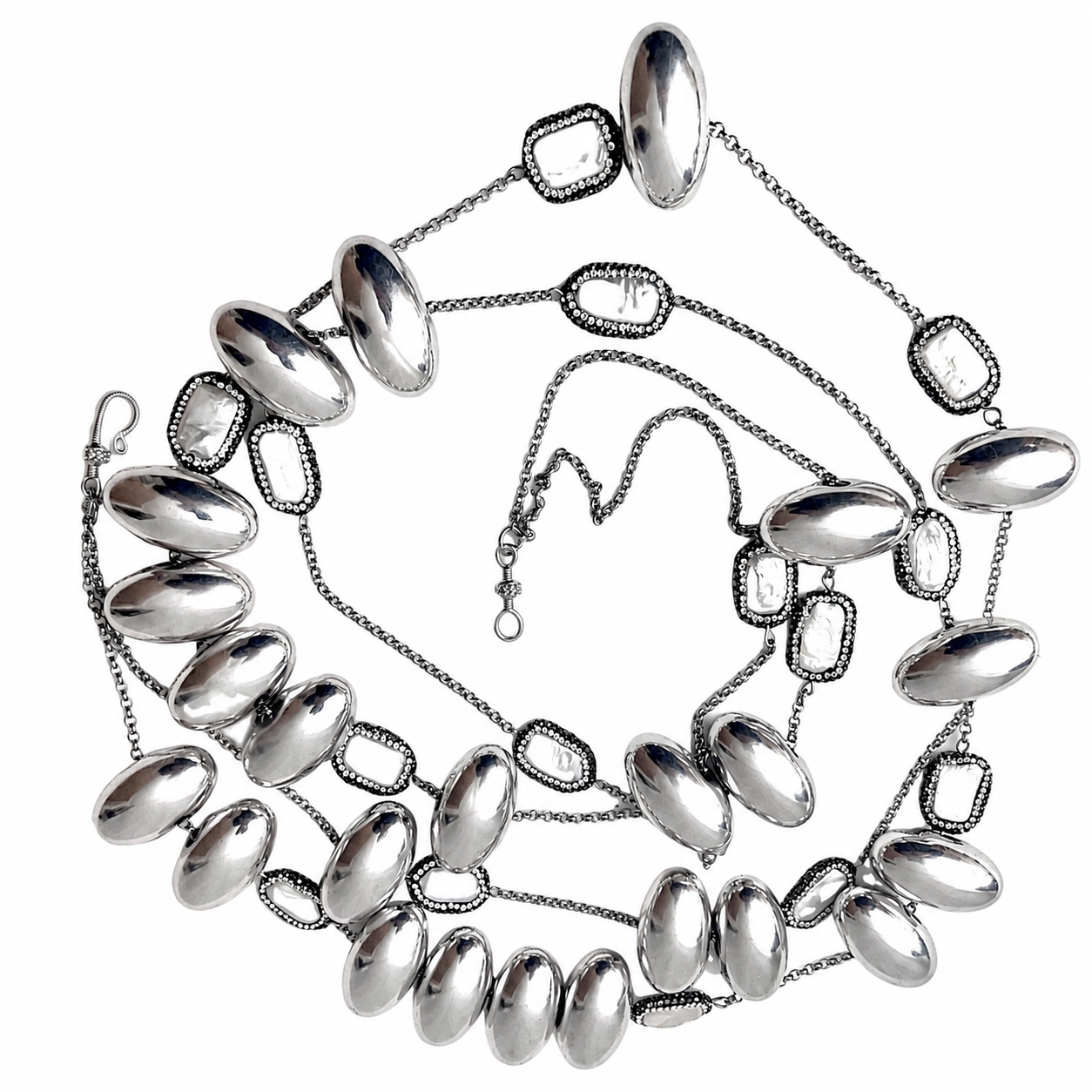 Two-strand silver necklace featuring large oval metallic beads and textured geometric links connected by fine chains. The beads have a mirror-like finish, while the links add contrast with their beaded edges. The necklace includes a small clasp and adjustable chain for length customization.