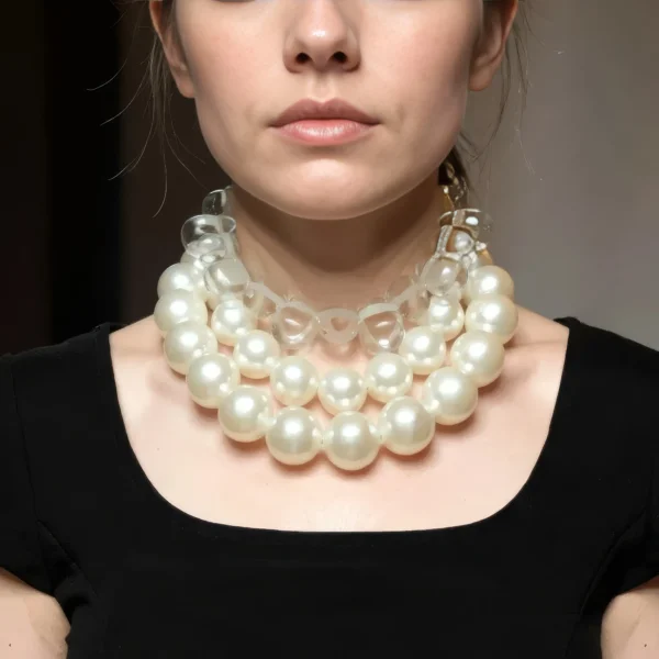 🤍 Drape yourself in modern elegance with this statement jewelry set—an exquisite pairing of classic charm and bold contemporary design. At its core are two versatile pieces: a choker necklace crafted from gleaming clear resin and tooth-shaped beads, and a double strand of medium-sized simulated pearls. Together, they offer layered sophistication with the flexibility to be worn individually or combined for dramatic effect. The clear beads inject a vibrant contrast, amplifying the luster of the pearls and transforming traditional styling into something uniquely expressive. With an extender offering up to 5 inches of adjustable length, the set ensures a perfect fit, whether you prefer it softly draping the neckline or resting high for a structured silhouette. This set is more than an accessory—it’s a showpiece that balances artistry and wearability. Lightweight yet substantial, each component adapts easily from daytime sophistication to evening glamour.  A nod to timeless regality, the set radiates with royal grace. Whether you wear the pearls alone, the choker solo, or both as a striking duo, the result is always confident, polished, and—yes—absolutely royal in presence. This is a set The clear beads choker measures 16 IN/5 OZ. The double-strand necklace measures 17 IN/ 10 OZ Extension up to 5 IN A set 16 IN/15 OZ