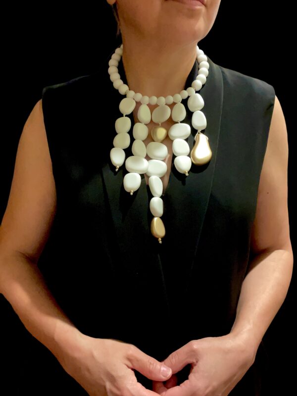 The choker measures 16 IN, and the longest strand of beads measures 28 IN.   The necklace design displays dangling acrylic white beads with gold accent beads.  This is a true white statement necklace that can be formal or informal.  The beads are pure white and stand out easily.  