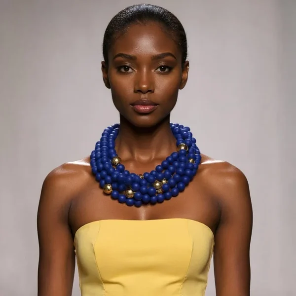 A cobalt blue statement in modern refinement, this striking beaded necklace is designed to captivate and impress. Its bold silhouette rests comfortably around the neck, making it effortlessly wearable for day or night occasions. At its core, the design pairs deep navy silicone beads with luminous gold accents, marrying softness and shine in a harmonious melody. Crafted with intention, the beads are meticulously strung to balance weight and flow, ensuring the piece catches light at every turn. The rich hue—evocative of the most vibrant oceanic depths—imbues the necklace with an air of mystery and allure. Accented by gold beads, the composition achieves a timeless elegance that elevates any ensemble. Perfect for those who dare to stand out, this necklace transforms simple outfits into gallery-ready statements. Whether layered over a crisp white blouse or contrasted against an evening gown, its dynamic color palette commands attention without overwhelming. The warm gleam of gold accents dances across the deep backdrop, creating a visually unforgettable moment. Versatile yet singular in appeal, this accessory is the epitome of graceful boldness. Let it be the focal point of your look, a conversation starter, and a symbol of confident style. In every setting, this dramatic necklace promises to turn heads and evoke admiration.
