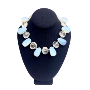 Experience the enchantment of natural beauty and artistry with our handcrafted necklace featuring luminous gemstones. This extraordinary piece showcases an elegant interplay between two distinct bead types, marrying subtle opalescence with earthy sophistication. The design revolves around the seamless union of Opalite Crystal beads and genuine Crystal Rock beads. Each element captures and reflects light in its own unique way, creating a dynamic dance of brilliance with every movement. The Opalite Crystal strands reveal a mesmerizing color effect that shifts from soft green to pale blue, lending the necklace an ethereal quality that changes with each glance. Complementing these hues, the Crystal Rock beads provide structure and clarity, grounding the iridescent glow in polished elegance. Capable of harmonizing with virtually any outfit, this versatile accessory transitions seamlessly from casual to formal settings. Whether paired with a crisp white blouse or a sleek evening gown, the subtle sparkle of Opalite Crystal details creates an eye-catching focal point without overwhelming the ensemble. More than an ornament, this necklace stands as a work of art, connecting fashion with raw earth elegance. The interplay of transparent beads and natural textures delivers a distinctive organic look, highlighting both craftsmanship and mindful design. Enhance your collection with this piece that brings a luminous perspective to any wardrobe.