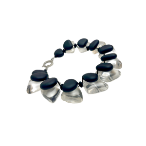 The Double Short Necklace is a bold statement piece featuring a double-strand design of large clear acrylic beads paired with matte black small beads. This modern aesthetic makes it versatile for both casual and formal wear, ensuring it stands out in any setting. Measuring 18 inches, the necklace includes an extension that adjusts up to 22 inches, allowing you to tailor the fit to your outfit and neckline. The double-strand design not only amplifies the visual impact but also adds structural strength, ensuring it drapes smoothly and maintains its shape. The striking contrast between transparent, chunky beads and sleek matte black accents creates an elegant yet contemporary look. Whether you style it solo over a crisp white shirt or layer it with other pieces for a more eclectic vibe, this necklace adapts effortlessly. Light enough for all-day wear yet substantial enough to elevate evening attire, the Double Short Necklace embodies modern sophistication. Its versatility makes it a must-have accessory that complements everything from minimalist ensembles to more elaborate outfits. With three subtle nods to its double-strand construction, this chunky necklace redefines refined edge. Add it to your collection for an instant refresh—versatility and impact, perfectly intertwined.