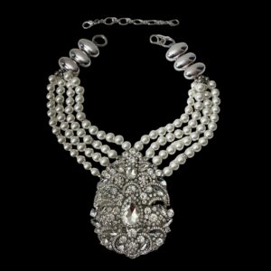 Multistrand necklace of simulation pearls and accent silver beads on an extra large brooch.