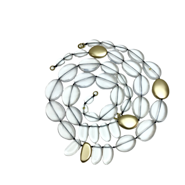 This exquisite, extra-long necklace features a stunning combination of clear beads interspersed with elegant gold accent beads, creating a sophisticated and eye-catching accessory. The harmonious blend of clear and gold tones adds a touch of luxury.  