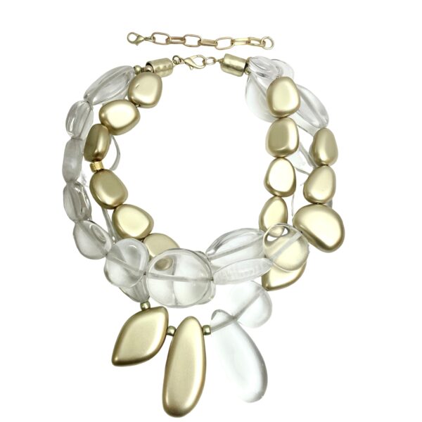 Our stunning three-strand necklace is artfully designed with an exquisite combination of clear and gold beads in asymmetric shapes.  The interplay of shimmering gold and crystal-clear beads creates a captivating visual effect.  