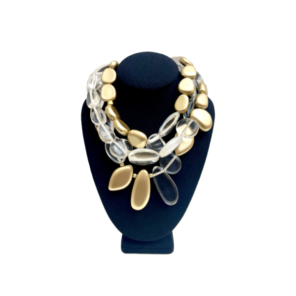 Our stunning three-strand necklace is artfully designed with an exquisite combination of clear and gold beads in asymmetric shapes.  The interplay of shimmering gold and crystal-clear beads creates a captivating visual effect.  