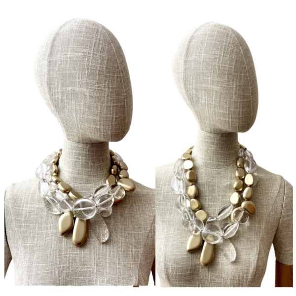 Our stunning three-strand necklace is artfully designed with an exquisite combination of clear and gold beads in asymmetric shapes.  The interplay of shimmering gold and crystal-clear beads creates a captivating visual effect.  