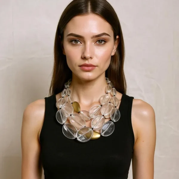 Crafted to command attention, this exquisite necklace with extended length features a stunning combination of clear beads interspersed with elegant gold accent beads. Its harmonious blend of transparent and metallic hues offers a luxurious sheen that captures light from every angle. Designed for versatility, you can wear it as a single strand with a long, flowy dress to achieve effortless grace. Simply slip it over the head for instant elevation of casual separates, or transform it into two long strands that cascade beautifully, adding depth and dimension to your look. For a bold, fashion-forward twist, double it up again to create a chunky, sculptural statement. Each bead is uniformly strung on a durable, tangle-resistant cord that drapes gracefully and maintains its poise throughout the day. The juxtaposition of crystal-clear forms and golden accents lends this piece an air of modern elegance while retaining timeless appeal. Perfect for both daytime sophistication and evening glamour, it transitions seamlessly from desk to dinner and beyond. Lightweight yet substantial, the design moves with your body, catching reflections with every turn. Allow this dramatic piece to take you from workwear to weekend attire, ensuring a lasting impression wherever you go.  Each clear bead reflects a prism of color, while gold accents cast a long glow.