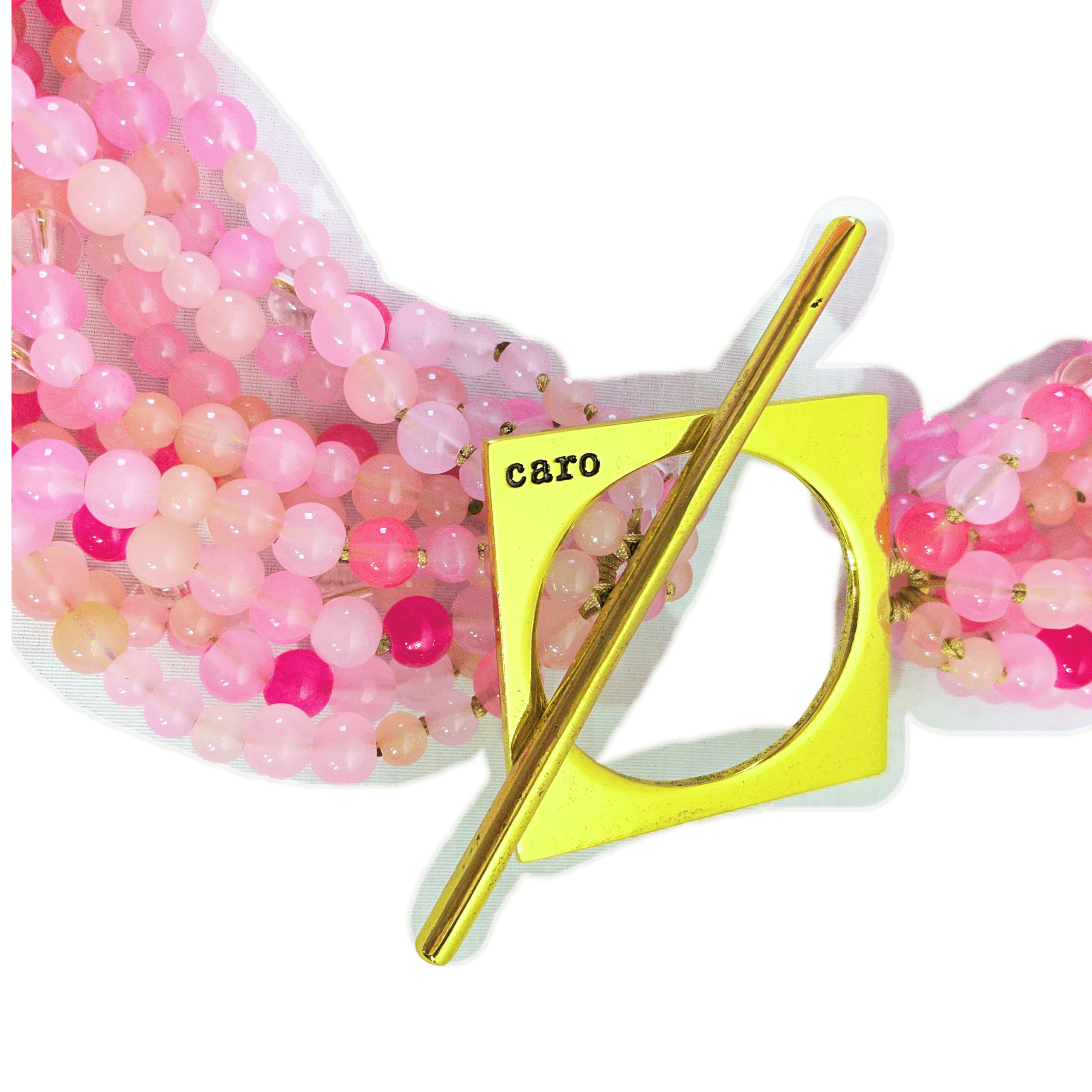 Make a bold statement with this Pink multi-strand glass bead necklace, designed to captivate with its rich texture and dynamic versatility. Measuring 22 inches in length and weighing 16 ounces, it offers a substantial yet graceful presence that complements both casual and formal attire. Crafted from small glass beads in varying shades of Pink, the strands create a layered effect that shimmers with movement and depth. Whether worn loose for a relaxed, bohemian vibe or twisted for a polished, evening-ready silhouette, this Pink necklace adapts effortlessly to your mood and style. A large gold toggle clasp anchors the design with a modern edge, positioned intentionally to rest on one side for an asymmetrical touch. The clasp’s geometric form adds contrast to the organic flow of the beads, elevating the piece with a sculptural accent. This necklace celebrates the beauty of color and craftsmanship, blending soft hues with bold structure. The Pink tones evoke warmth and femininity, while the gold clasp introduces a refined finish. Ideal for those who appreciate jewelry that transforms with intention, this piece invites you to express your individuality—one twist, one strand, one radiant moment at a time.