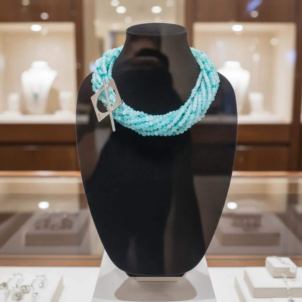 Elevate your ensemble with our Sky Cascade Necklace—a versatile statement piece inspired by the shifting hues of the open sky. This handcrafted design features multiple strands of petite glass beads in a harmonious gradient of blues, from deep ocean tones to the soft whisper of morning mist. Each bead catches the light like droplets suspended in air, creating a fluid, shimmering effect that evokes the serenity of a clear heaven at dawn. The necklace is anchored by a bold silver toggle clasp, intentionally placed to one side for a touch of asymmetrical elegance. This distinctive clasp not only secures the piece but adds a sculptural accent that complements both casual and formal looks. Wear it loose for a layered, bohemian vibe, or twist the strands for a more refined silhouette—perfect for evening wear or special occasions. Whether you're channeling the calm of a cloudless Sky or the depth of twilight blues, this necklace adapts to your mood and style. Designed for those who find beauty in nuance and movement, the necklace is more than an accessory—it’s a wearable reflection of nature’s palette and your personal expression. Let your style soar.