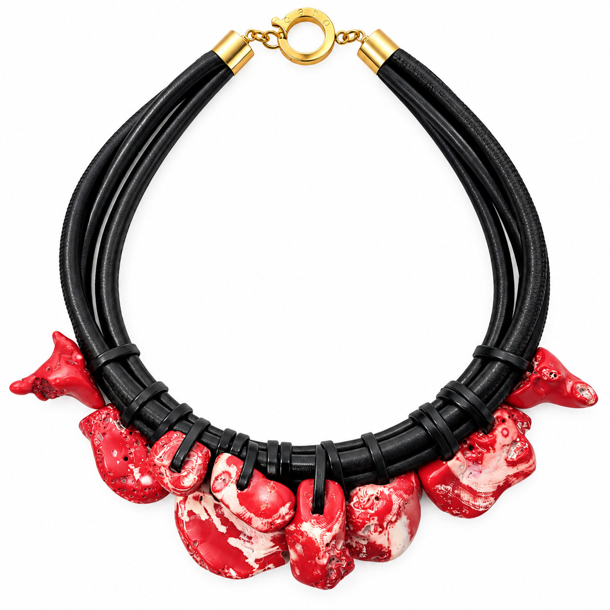Bold sculptural necklace featuring three thick black cords joined with gold end caps and a circular clasp. Along the lower edge hang irregularly shaped marbled red and white coral pieces, each unique in form and texture, creating a dramatic contrast against the sleek black cords.
