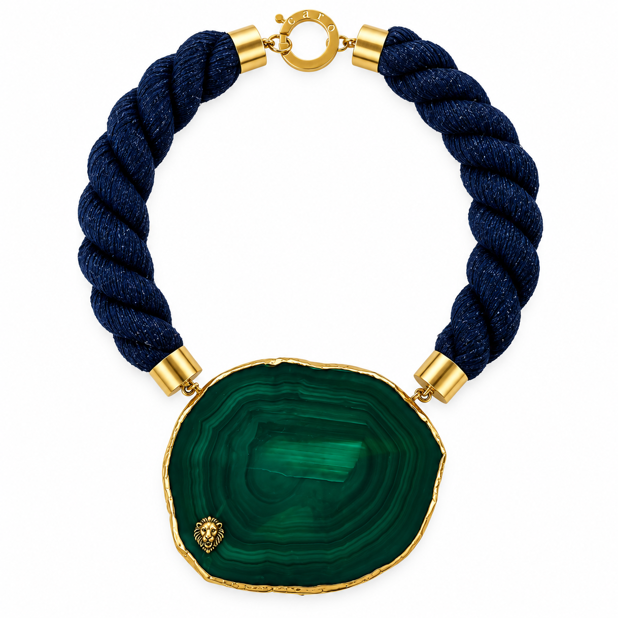 Statement necklace featuring a large polished green agate slice with visible natural banding patterns and a thin gold-toned border. The pendant is attached to thick, twisted navy cords with gold metal end caps and a circular clasp engraved with “caro.” The design combines organic stone beauty with modern craftsmanship.