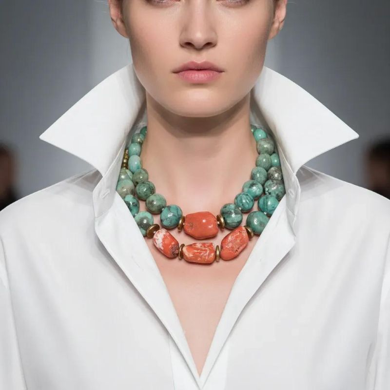 Amazonite Cluster Combo Layered color. Natural harmony. Effortless statement.   This Amazonite Cluster brings together two beautifully coordinated necklaces—products 0369242 and 0369243—designed to be worn as a striking layered duo or enjoyed individually. Each piece is crafted from natural amazonite, celebrated for its soothing blue‑green tones, and vibrant orange coral that adds a warm, energizing contrast. Gold‑accented coconut spacer beads introduce an earthy elegance, creating a balanced rhythm between color, texture, and shine. Both necklaces measure 18 inches in length and are fully adjustable, allowing you to achieve the perfect layered silhouette. When worn together, they create a bold, dimensional look that sits gracefully along the neckline. Combined, the two pieces weigh 14 ounces—substantial enough to feel luxurious, yet comfortable for all‑day wear. The Amazonite Cluster is ideal for those who love versatility. Wear the full combo for a dramatic, curated statement, or separate the pieces to suit your mood, outfit, or occasion. Each necklace stands beautifully on its own, yet together they form a cohesive, artful pairing that elevates any style. Whether you’re drawn to the calming presence of amazonite, the fiery charm of coral, or the richness of layered design, this combo offers endless ways to express your individuality.  You can purchase either piece separately by searching for the product number, or purchase this combo at a lower price.