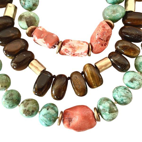 Combination Trio Necklace Three energies. Three colors. One striking harmony. This Combination brings together products 0369242, 0369243, and 0369245 into a beautifully curated trio designed for effortless layering. Each necklace is crafted from natural stones—soothing Amazonite, vibrant Coral, and shimmering Tiger Eye—creating a stunning interplay of color, texture, and personality. The cool blue‑green of Amazonite, the fiery warmth of Coral, and the golden depth of Tiger Eye form a palette that feels both bold and balanced, earthy yet elevated. All three pieces are fully adjustable, allowing you to layer them with ease and customize the drape to suit your neckline and style. Worn together, they create a dimensional, artful statement that instantly transforms any outfit. Worn individually, each necklace stands on its own as a unique expression of natural beauty. This Combination offers versatility, artistry, and value. You can purchase each piece separately by searching its product number, or choose the full trio for a better price and a complete, ready‑to‑wear layered look. Whether you’re drawn to the calming presence of Amazonite, the energizing spark of Coral, or the grounding strength of Tiger Eye, this trio brings them together in a way that feels intentional, expressive, and unmistakably striking.