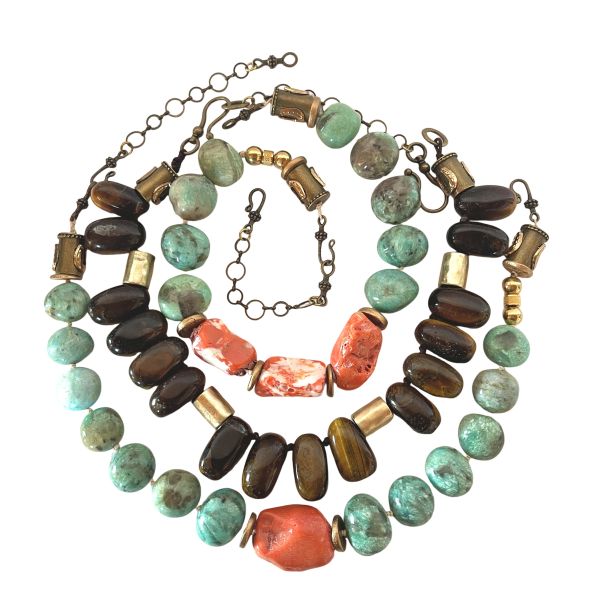 Combination Trio Necklace Three energies. Three colors. One striking harmony. This Combination brings together products 0369242, 0369243, and 0369245 into a beautifully curated trio designed for effortless layering. Each necklace is crafted from natural stones—soothing Amazonite, vibrant Coral, and shimmering Tiger Eye—creating a stunning interplay of color, texture, and personality. The cool blue‑green of Amazonite, the fiery warmth of Coral, and the golden depth of Tiger Eye form a palette that feels both bold and balanced, earthy yet elevated. All three pieces are fully adjustable, allowing you to layer them with ease and customize the drape to suit your neckline and style. Worn together, they create a dimensional, artful statement that instantly transforms any outfit. Worn individually, each necklace stands on its own as a unique expression of natural beauty. This Combination offers versatility, artistry, and value. You can purchase each piece separately by searching its product number, or choose the full trio for a better price and a complete, ready‑to‑wear layered look. Whether you’re drawn to the calming presence of Amazonite, the energizing spark of Coral, or the grounding strength of Tiger Eye, this trio brings them together in a way that feels intentional, expressive, and unmistakably striking.
