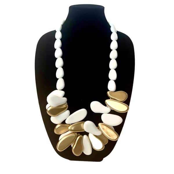 Inspired by freedom, this necklace embodies the essence of a Free Spirited Long—unbound, expressive, and beautifully bold. Crafted from smooth matte white beads, it is elevated by a cluster of high‑shine gold accents that catch the light with every movement. The contrast between the soft, matte finish of the white beads and the reflective brilliance of the gold creates a striking balance of calm and radiance. Measuring 33 inches and weighing 14 ounces, this piece offers a substantial yet comfortable presence. Its sculptural silhouette draws the eye to the center, where the gold cluster forms a focal point reminiscent of sunlit pebbles gathered along a shoreline. The necklace drapes gracefully across the chest, making it an ideal statement piece for both casual and elevated styling. Whether paired with natural linens, crisp cottons, or evening textures, this necklace adds a touch of organic elegance to any look. Its clean lines and warm metallic accents make it versatile enough for everyday wear while still delivering the impact of a gallery‑worthy accessory. A piece for those who move with intention and embrace beauty in simplicity, it stands as a reminder that style can be both grounded and luminous. See it paired with product 0369254 Free Spirited, sold separately.