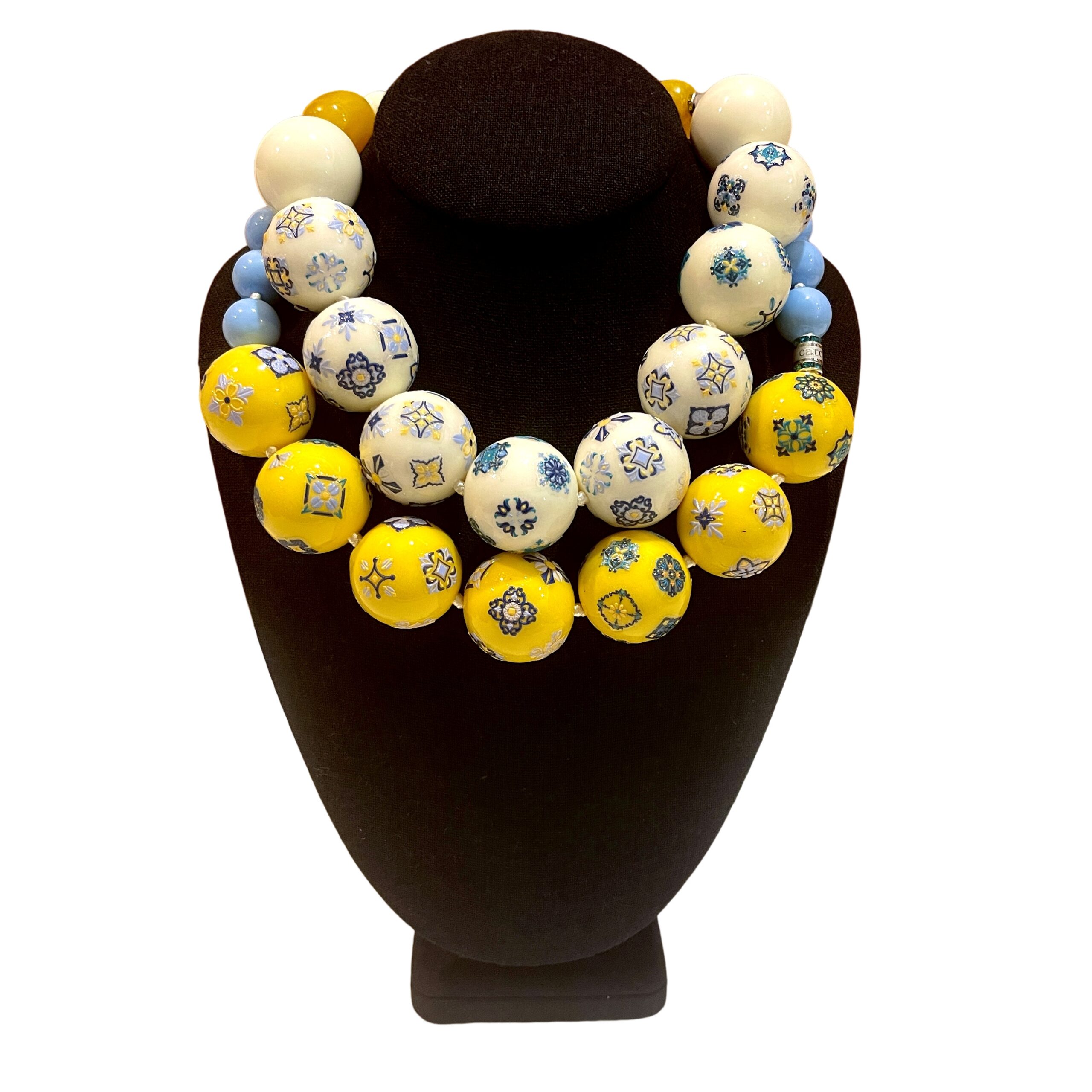 Two‑strand acrylic bead necklace set featuring Egyptian tile motifs in off‑white and yellow tones, displayed on a white background.