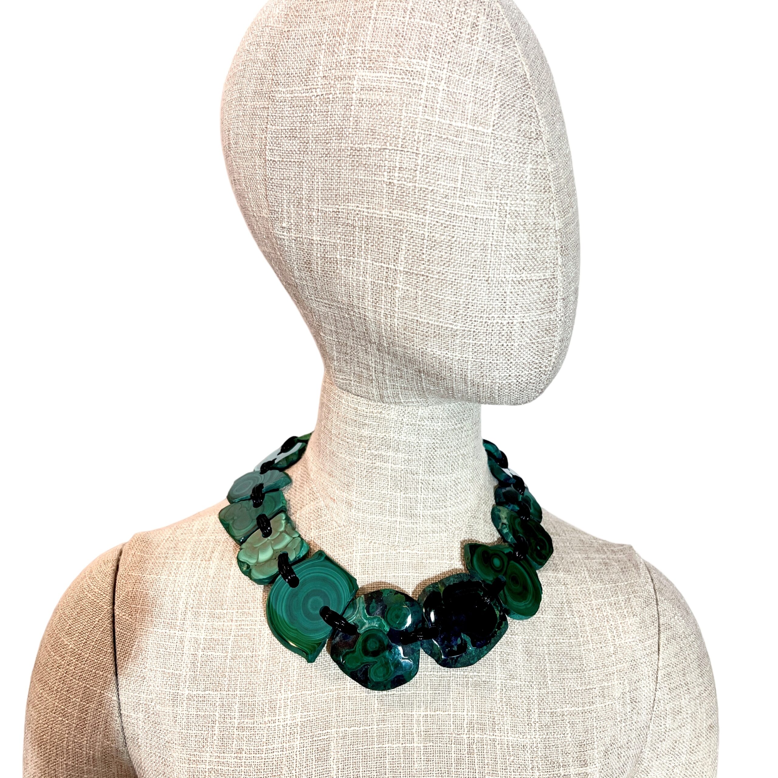 Raw malachite slab necklace with natural green banding linked by cord.