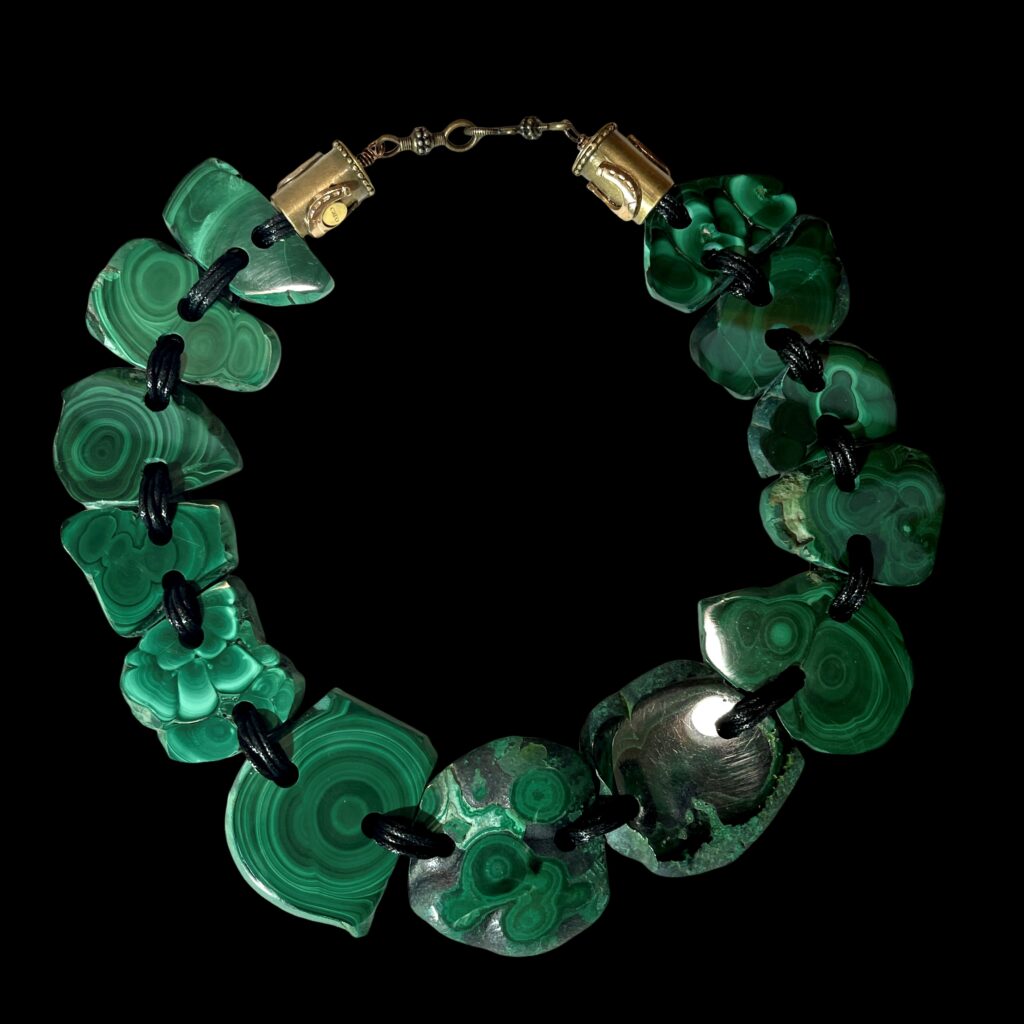 Raw malachite slab necklace with natural green banding linked by cord.